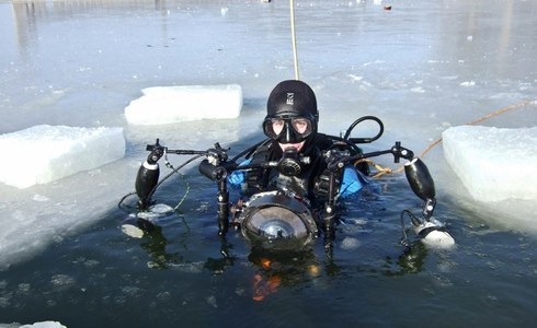 Onderwaterfotograaf Yoeri van Es met zijn apparaat tijdens een ijsduik