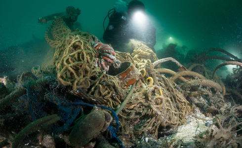 Duiker snijdt netten tijdens duikexpeditie - Foto: Cor Kuyvenhoven