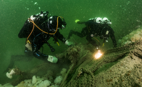 Duikers snijden onder water spooknetten los - Foto: Cor Kuyvenhoven